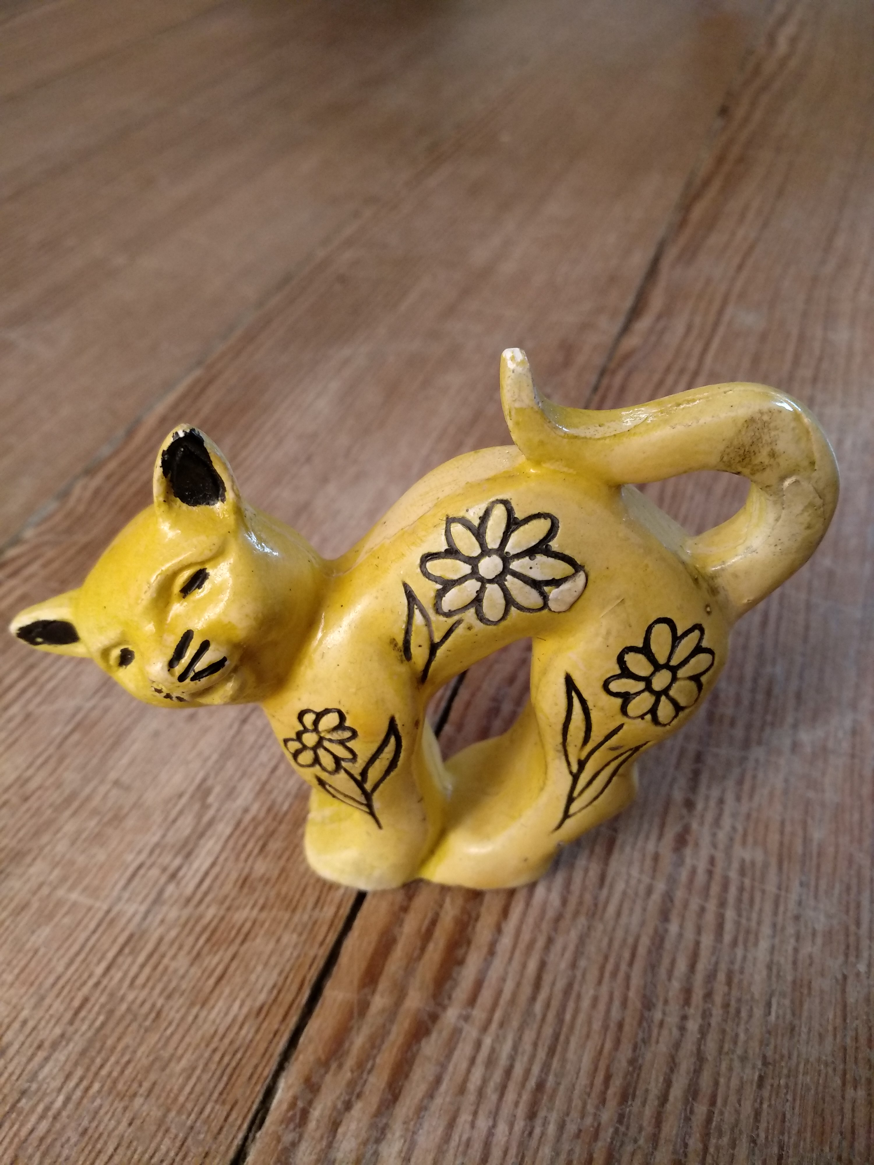 Yellow figurine of arched back cat