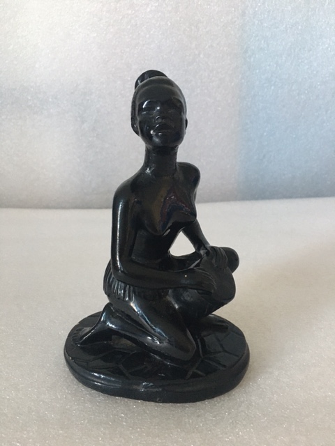 Kneeling lady black chalkware figurine on a circular base