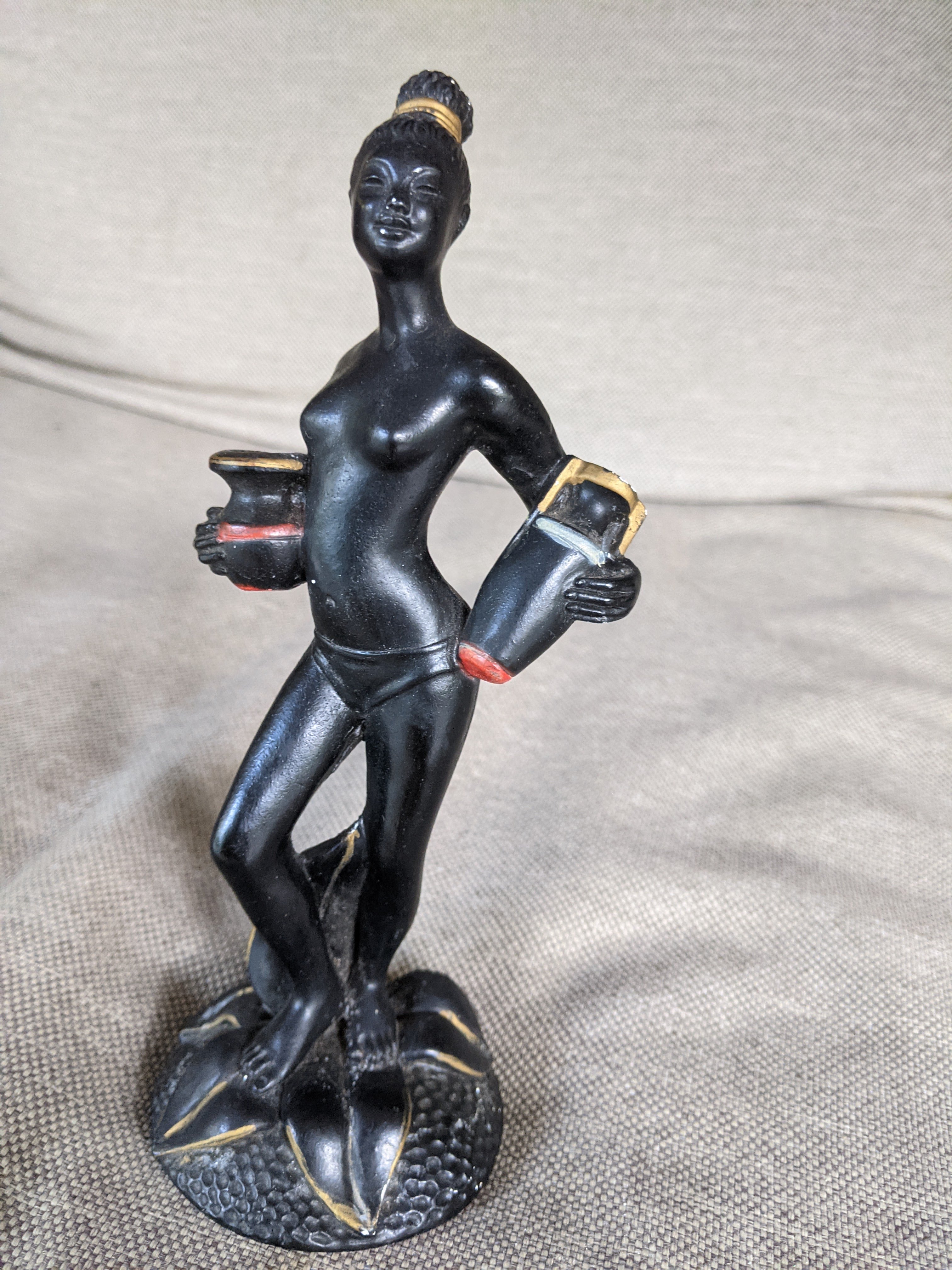 Tall topless lady figurine made of chalkware that is holding a tall and short vase in left and right hands