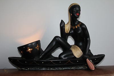 Girl on canoe back chalkware figurine