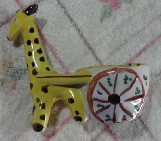 Giraffe eggcup with yellow skin towing a white cart