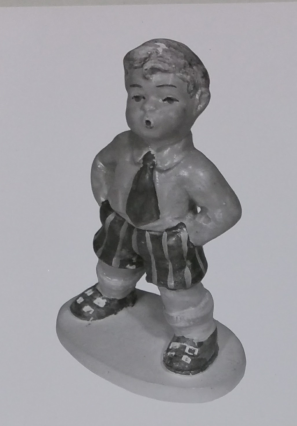 Whistling boy figurine