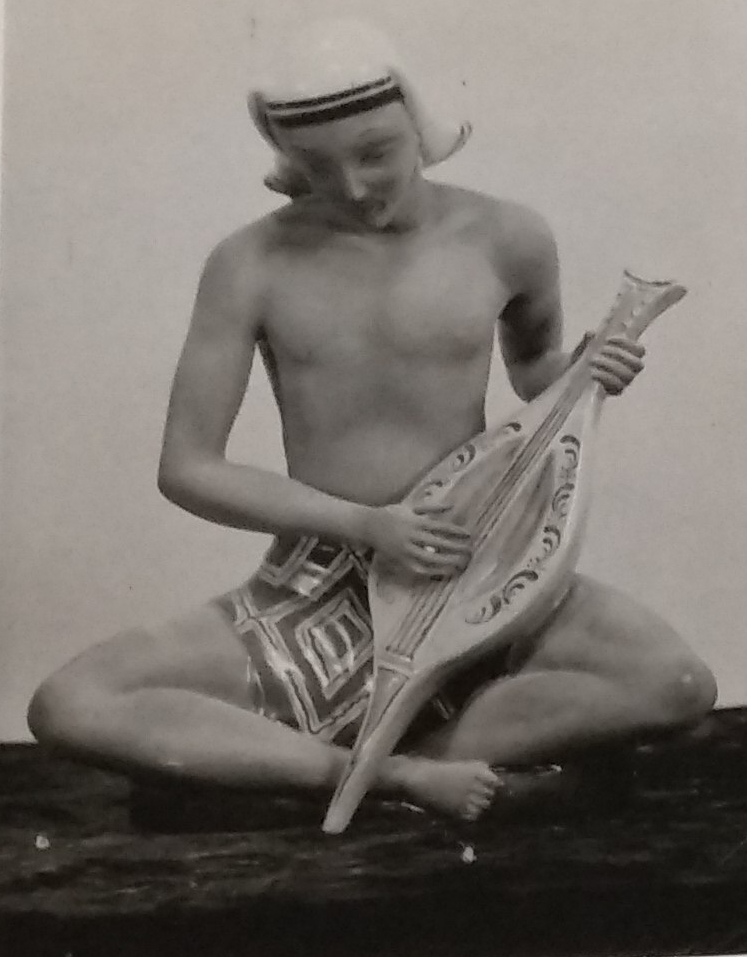 Male figurine holding musical instrument