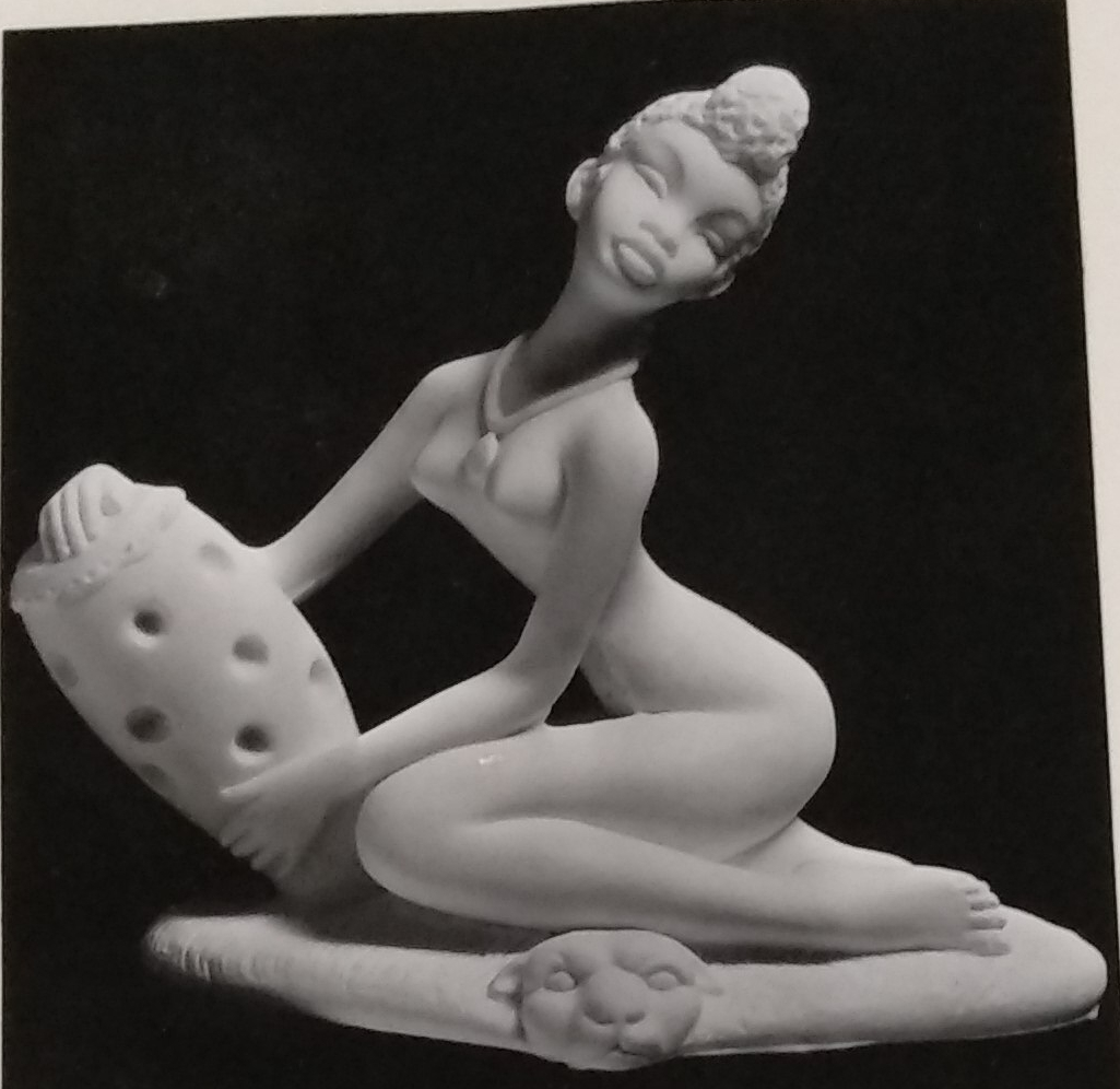 Seated lady made of chalkware holding vase