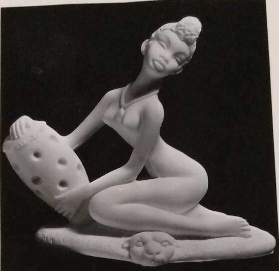Seated lady made of chalkware holding vase
