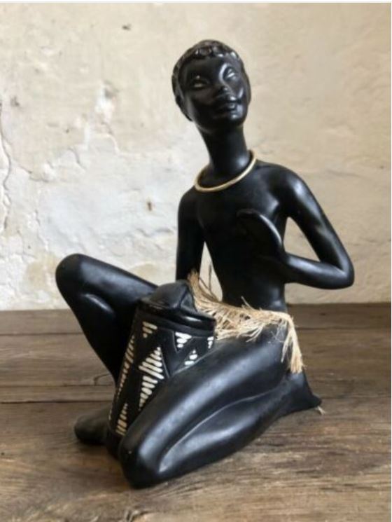 Seated drummer with tall drum between legs