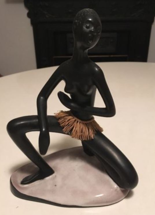 Kneeling black chalkware statue with dry grass skirt