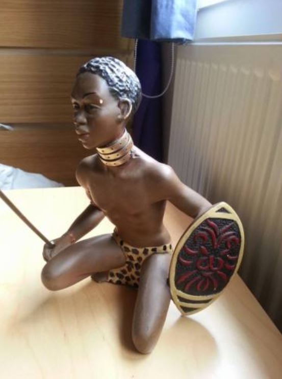 Kneeling warrior chalkware statue with red shield