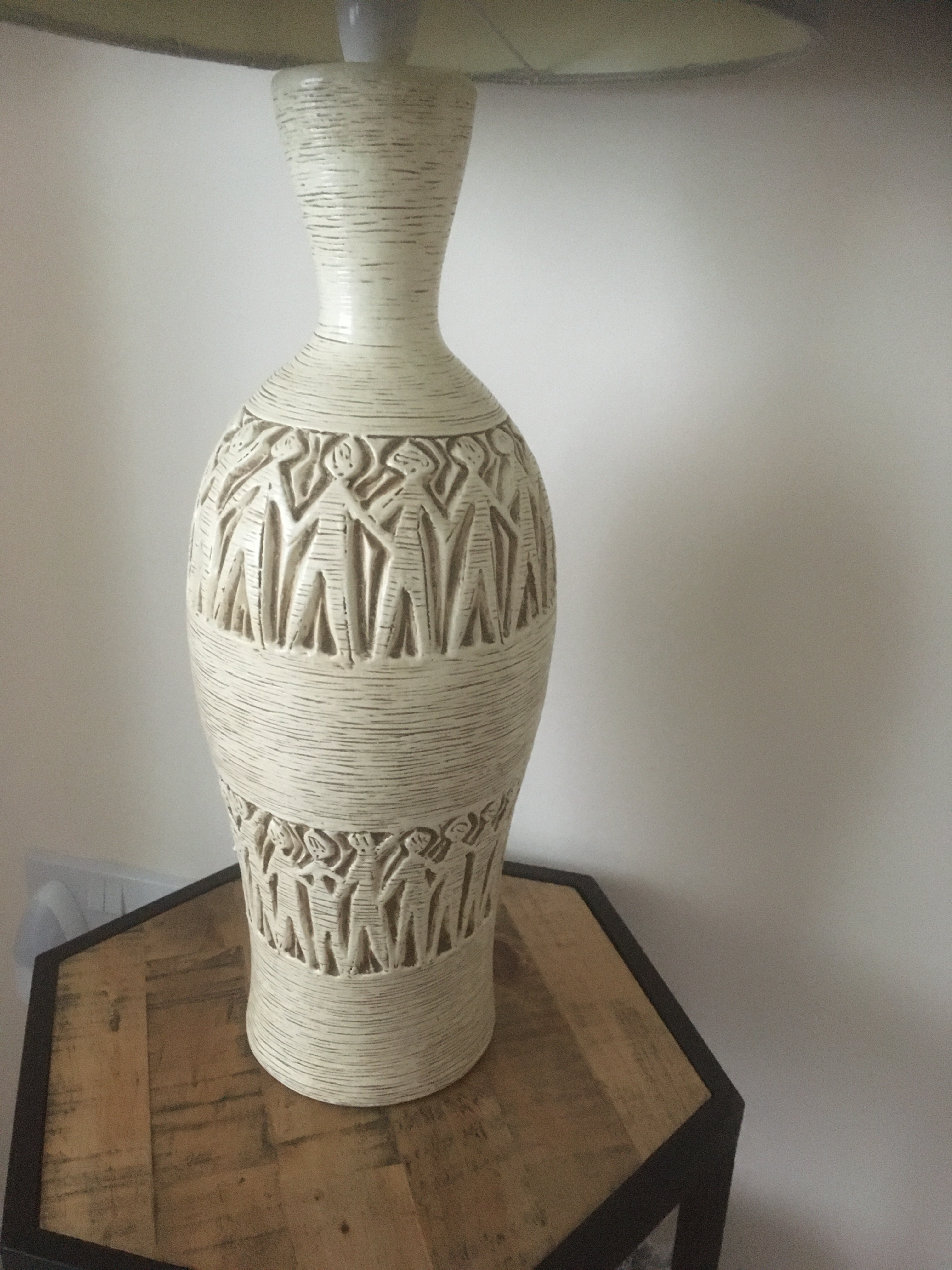 Tall standard lamp showing outlined stick figures in two circles round the cylindrical object