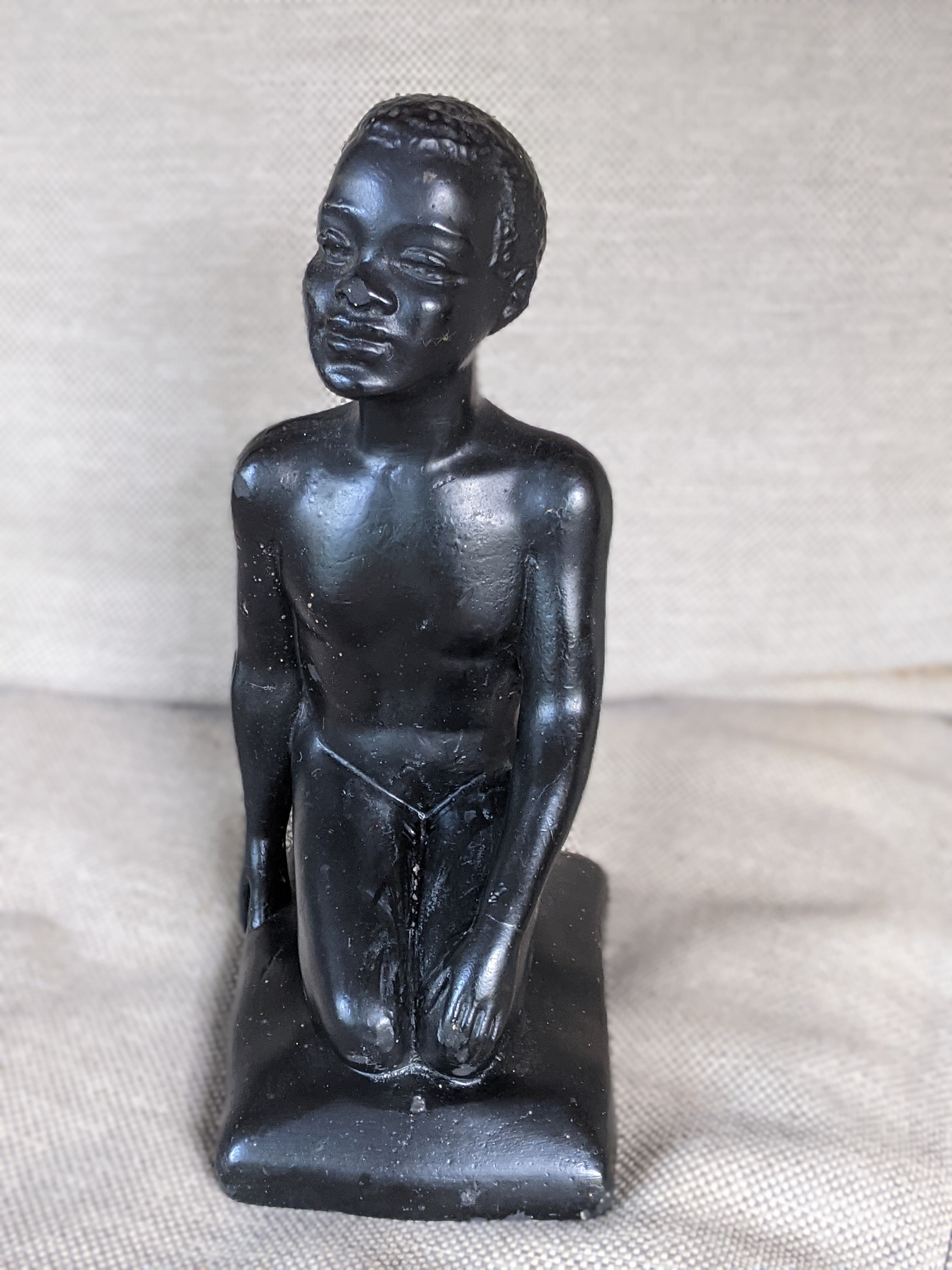 Chalkware figurine of a male seated on his legs