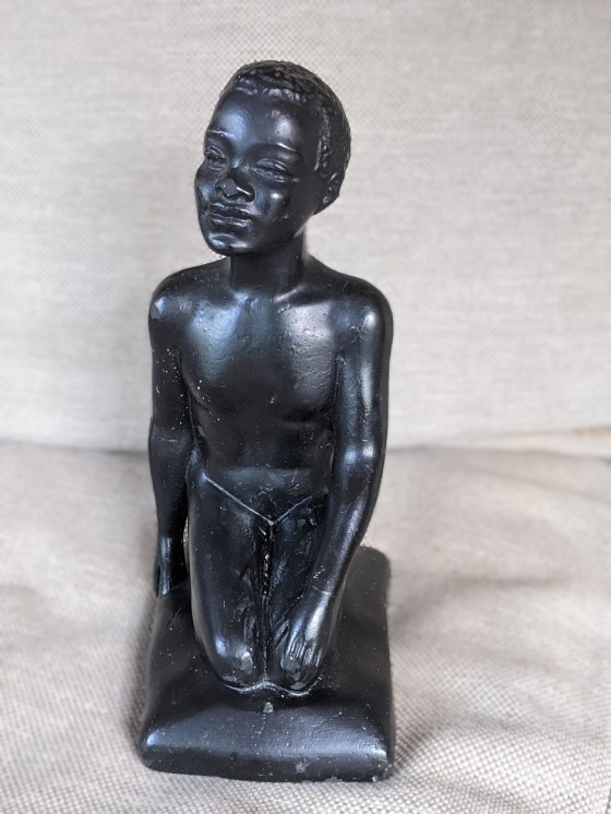 Chalkware figurine of a male seated on his legs