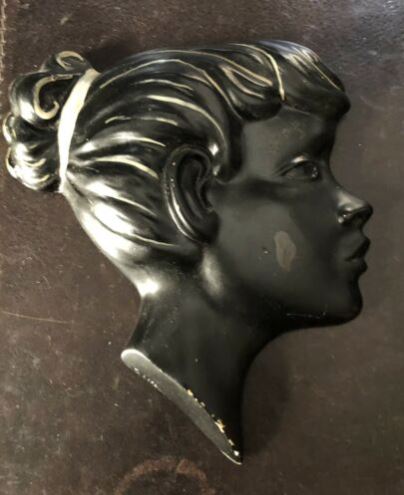A wall plaque made of chalkware of a girl